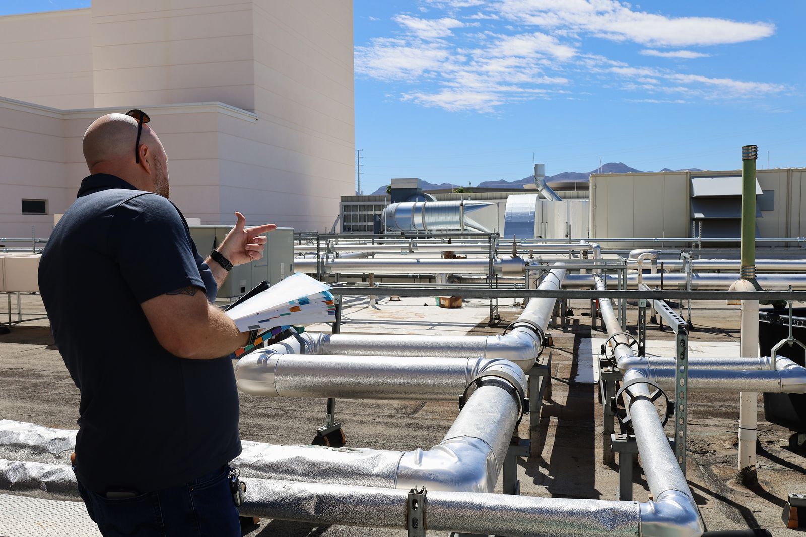 Rob Warnell on a rooftop looking over insulated piping runs