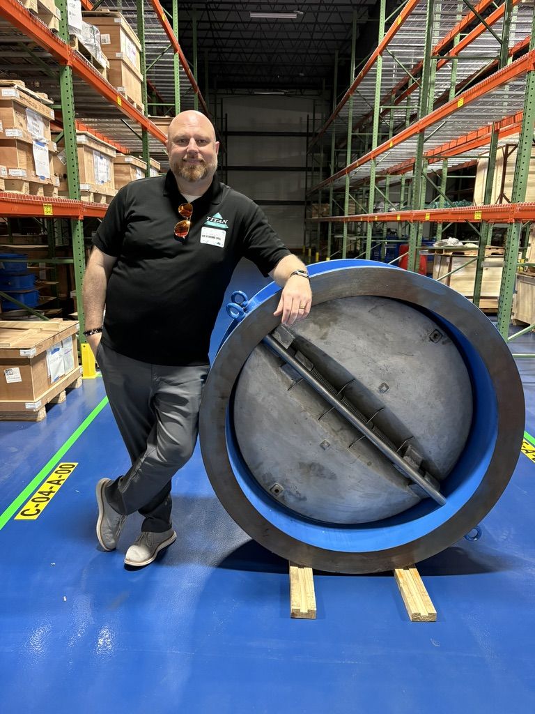 Rob Warnell with a large Titan dual-plate wafer check valve in a warehouse